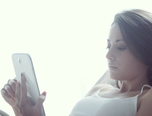 vrouw-ligt-in-bed-met-tablet-social-media-verslaving